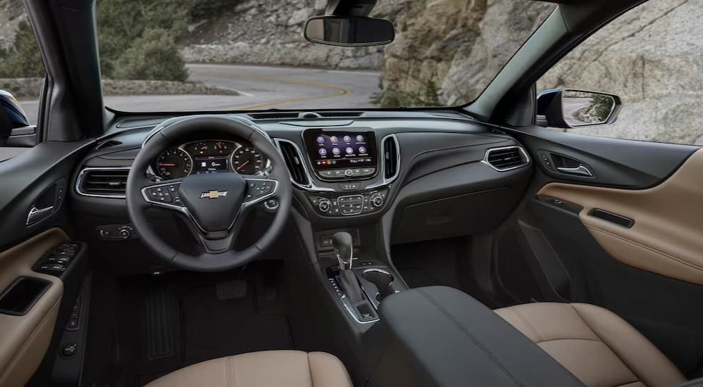 The black and tan interior and dash of a 2023 Chevy Equinox LS is shown.