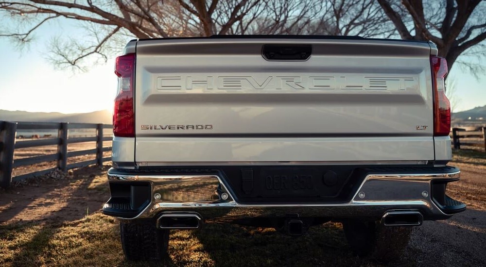 The backside of a 2023 Chevy Silverado 1500 LTs bed is shown on a countryside road.