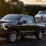 A black 2023 Chevy Silverado 1500 LTZ is shown towing a boat.