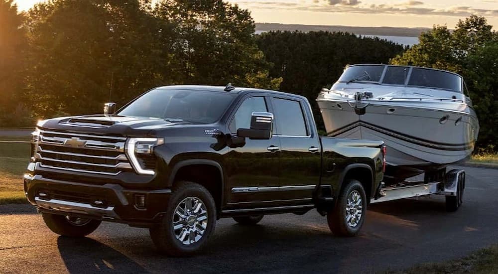 A black 2023 Chevy Silverado 1500 LTZ is shown towing a boat.