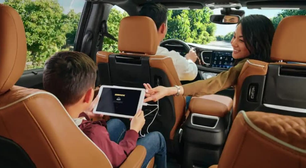 The black and brown interior and dash of a 2023 Chrysler Pacifica is shown.