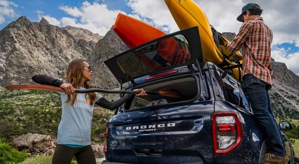 Two people are shown unloading gear off of a blue 2023 Ford Bronco Sport Big Bend.