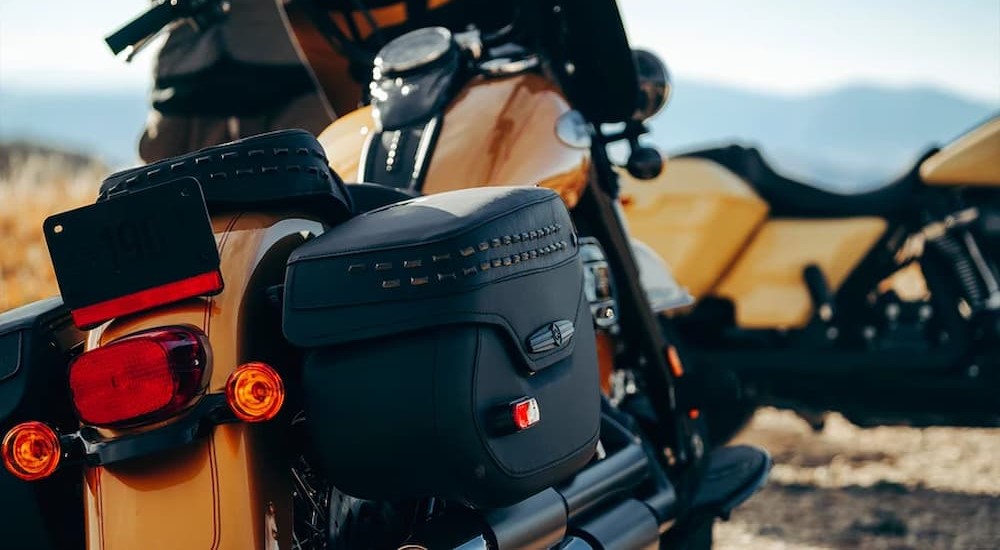 A black saddlebag is shown on the rear end of a black and orange 2023 Harley-Davidson Heritage Classic.