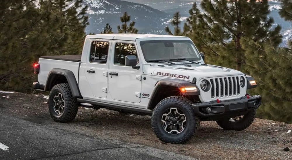 A white 2023 Jeep Gladiator Rubicon is shown parked near a mountain.