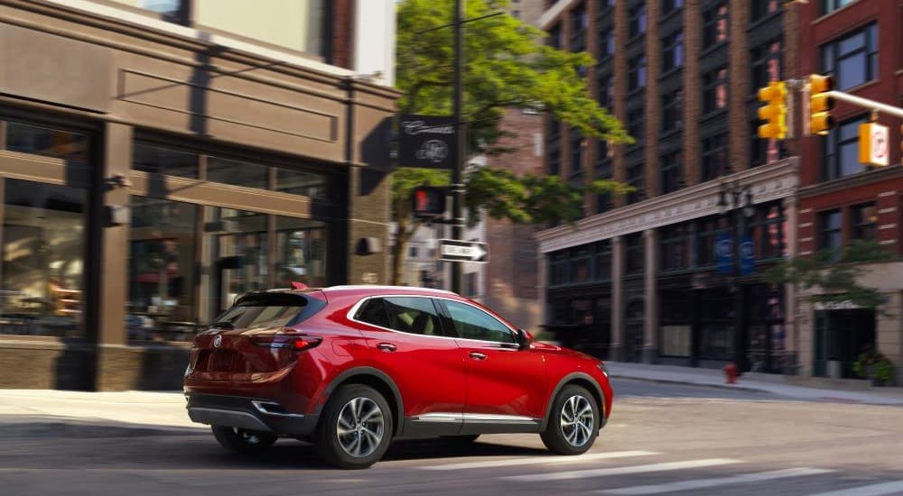 A red 2023 Buick Envista is shown driving on a city road.