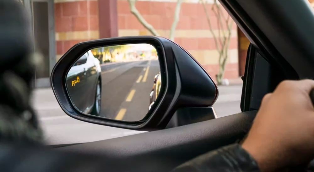 A close-up of a side mirror is shown on a 2023 Toyota Camry.