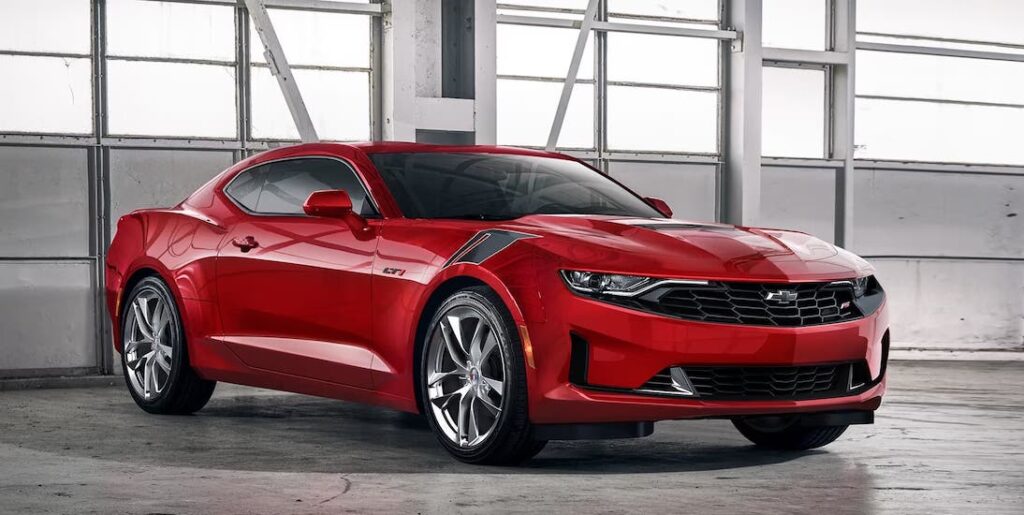 A red 2024 Chevy Camaro is shown parked in a bright garage.