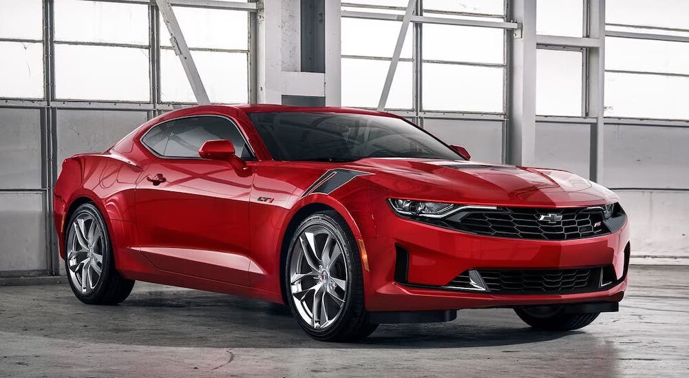 A red 2024 Chevy Camaro is shown parked in a bright garage.