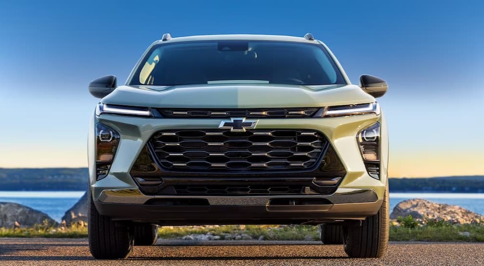 A green 2024 Chevy Trax is shown parked near a lake.