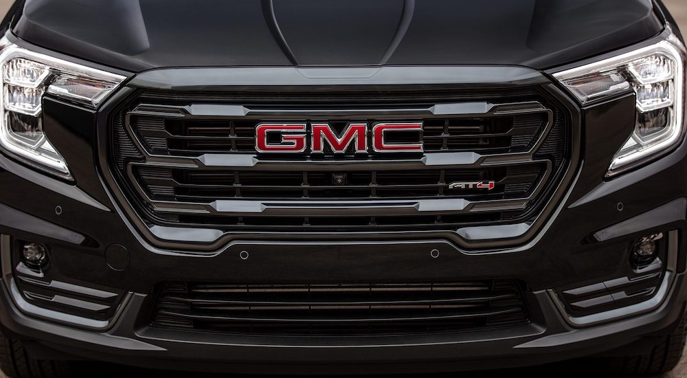 A close-up on the hood of a black 2024 GMC Terrain AT4 is shown.