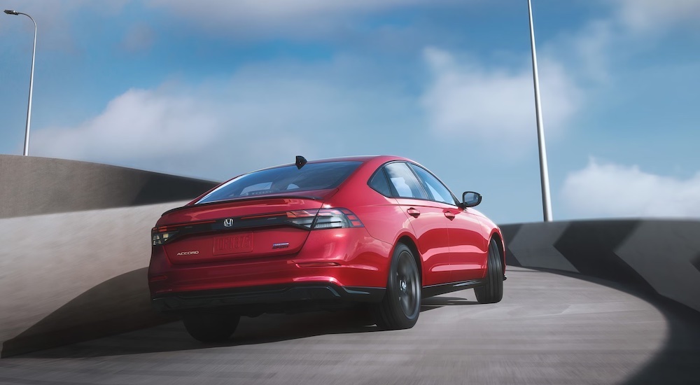 A red 2024 Honda Accord is shown driving up a bridge from behind.