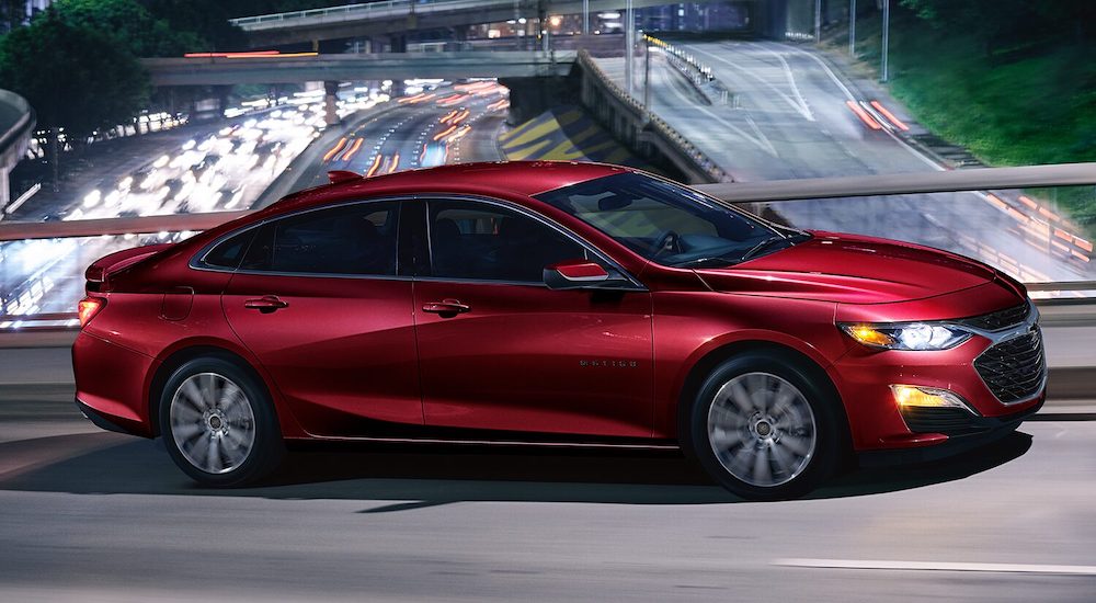 A red 2024 Chevy Malibu is shown driving.