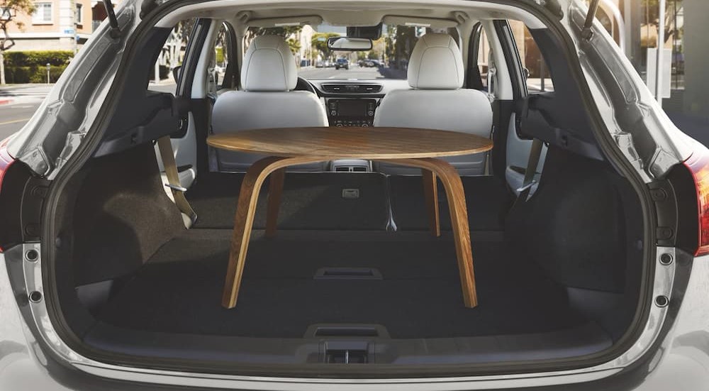 The white and black interior cargo space of a 2022 Nissan Rogue Sport is shown storing a table.