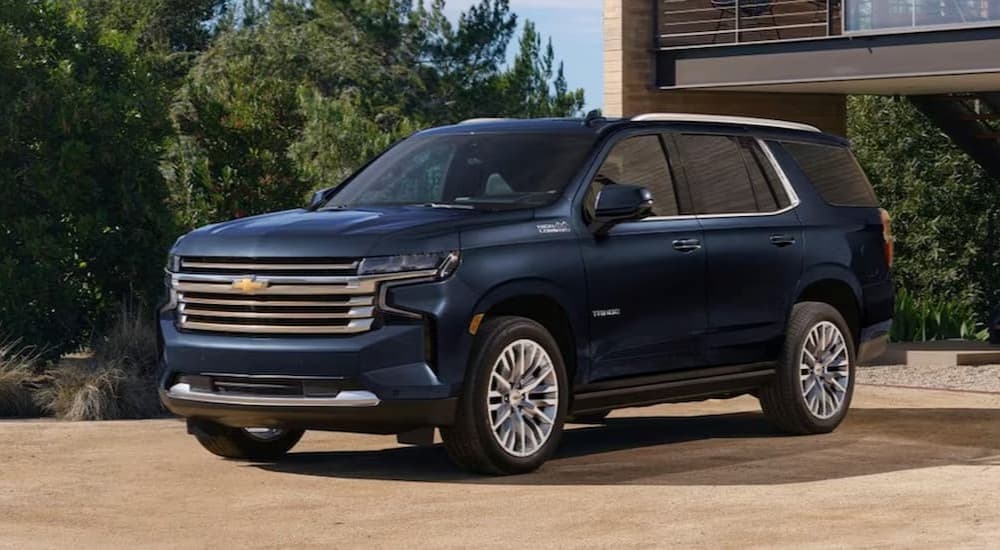 A blue 2023 Chevy Tahoe High Country is shown parked on a driveway.