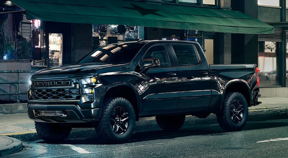 A black 2023 Chivy Silverado 1500 Z71 Midnight Edition Trail Boss is shown parked on a city street.