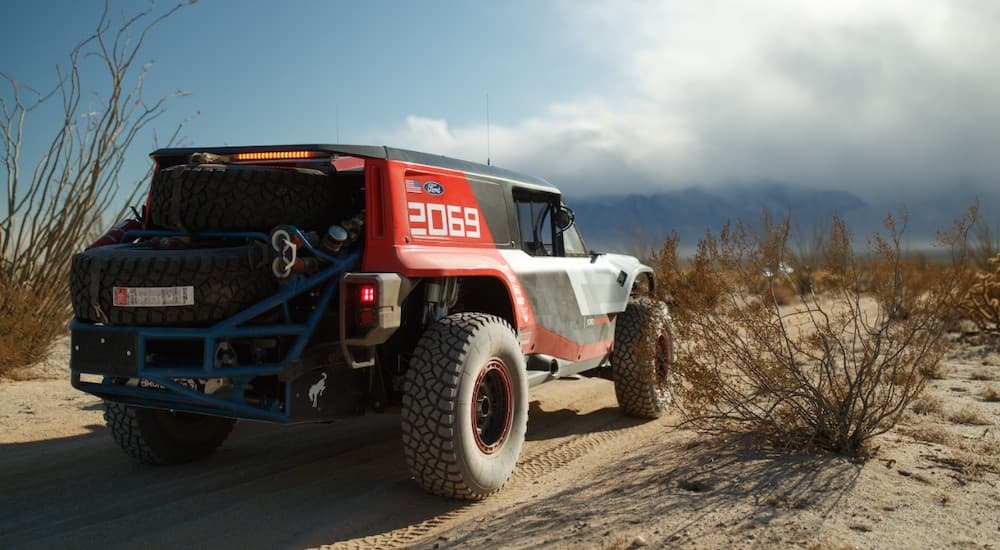 A red and black 2020 Ford Bronco R is shown racing down a desert road.