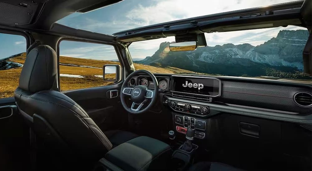 The black interior and dash of a 2024 Jeep Wrangler is shown.