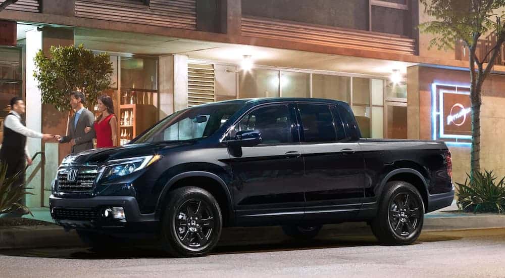 A black 2020 Honda Ridgeline Black Edition is shown parked near a restaurant after viewing used trucks for sale.