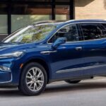 A blue 2023 Buick enclave is shown parked near a curb.