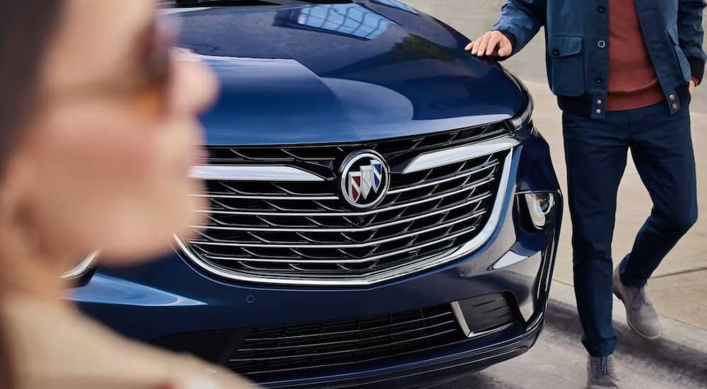 A close-up view of the grille of a blue 2023 Buick Enclave is shown.