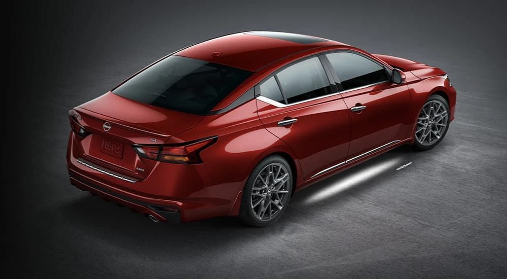 A red 2023 Nissan Altima is shown parked in a garage.