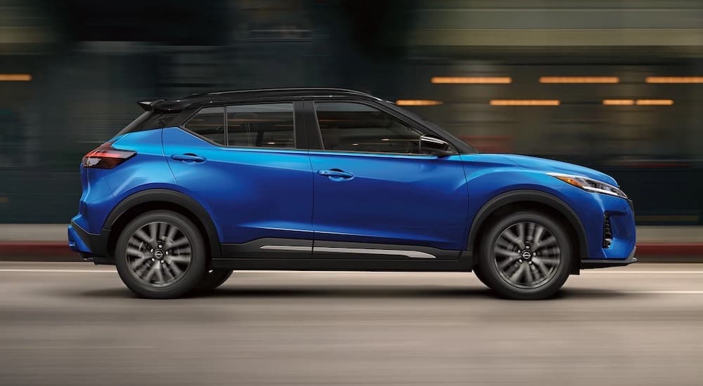 A blue 2023 Nissan Kicks S is shown from the side driving through a tunnel.