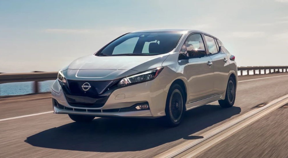 A white 2023 Nissan LEAF is shown driving.