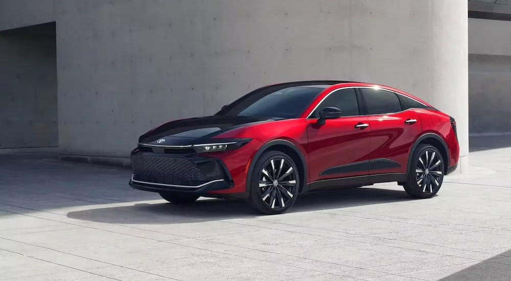 After reviewing bad credit car loans a red and black 2023 Toyota Crown is shown parked near an entrance.