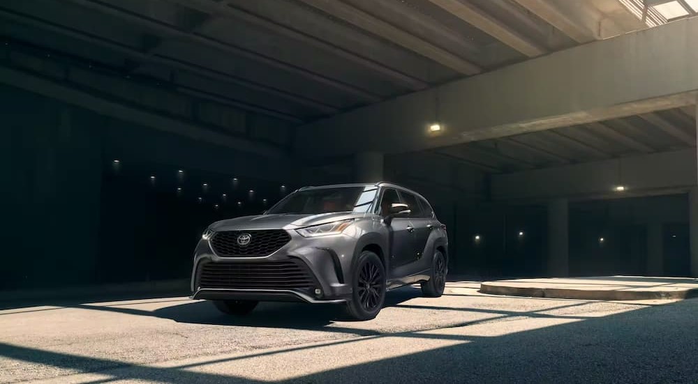 A gray 2023 Toyota Highlander is shown parked under sunlight.