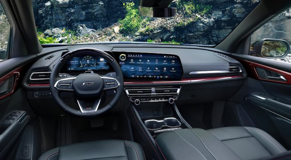 The black interior of a 2024 Chevy Traverse Z71 is shown, including the wheel and dashboard screen.