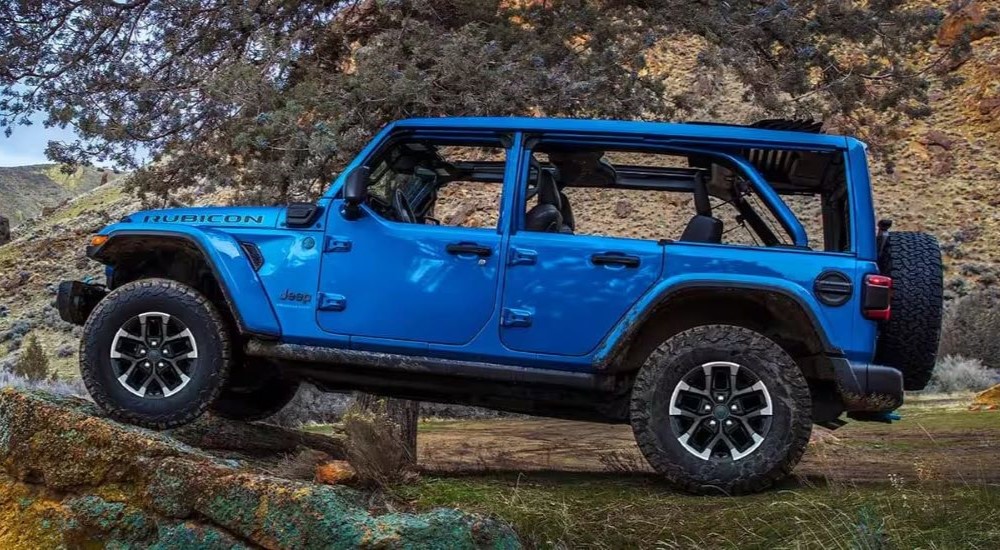 A blue 2024 Jeep Wrangler 4xe Rubicon is shown from the side.