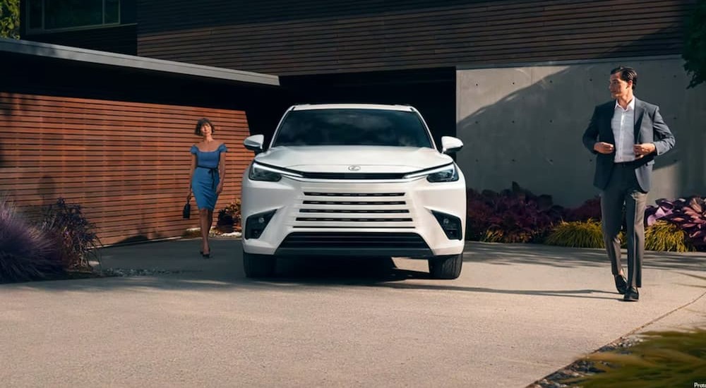 A white 2024 Lexus TX is shown parked near a house.