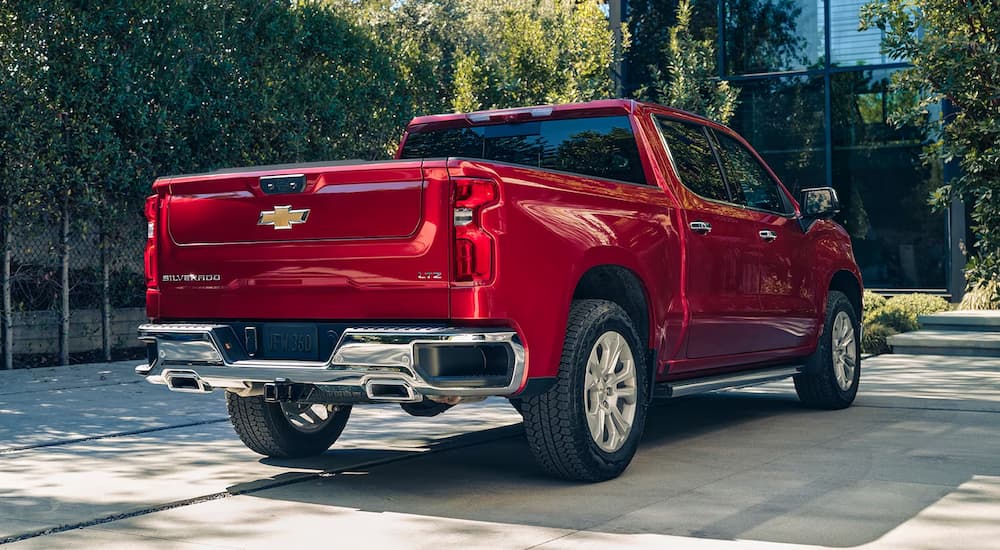 A red 2024 Chevy Silverado 1500 LTZ is shown from the rear parked on a driveway.