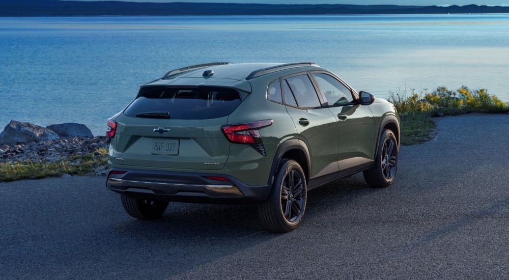 A green 2024 Chevy Trax Activ is shown parked near a lake.