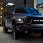 A black 2023 Ram 1500 Classic is shown driving from a Ram dealer.
