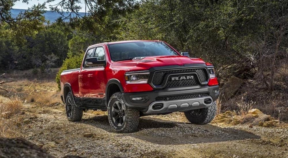 A red 2019 Ram 1500 is shown driving away from a used Ram dealership.