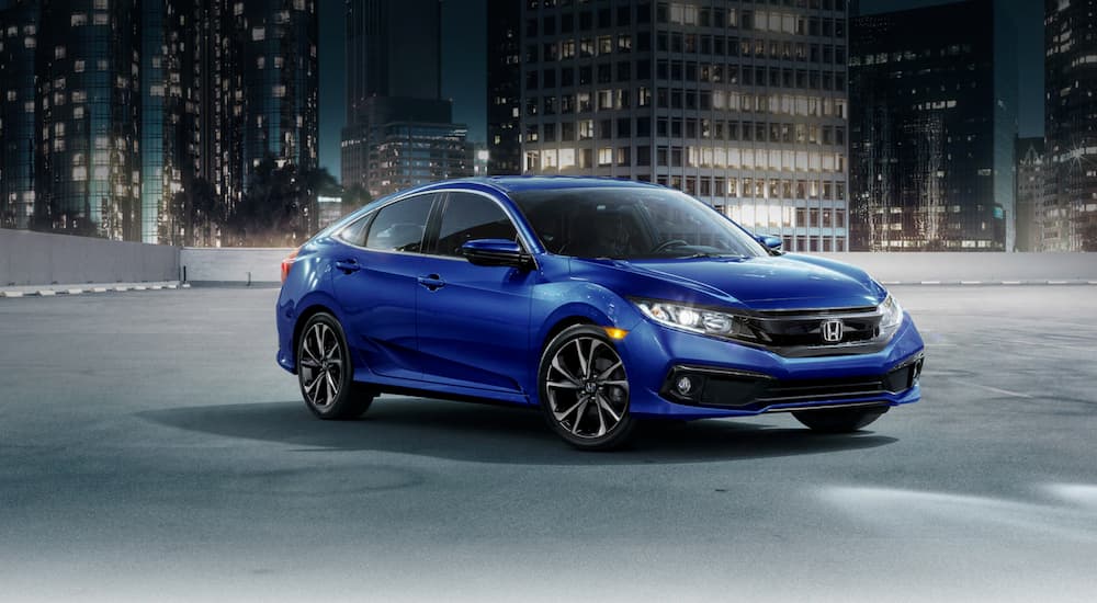 A blue 2021 Honda Civic is shown parked near a used Honda dealer.