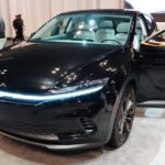 Inspired by current EVs for sale, the black 2025 Chrysler Airflow concept vehicle is shown on display at a car show.