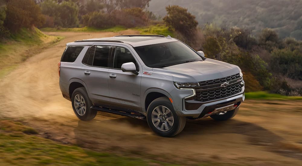 A white 2023 Chevy Tahoe Z71 is shown driving on a trail.