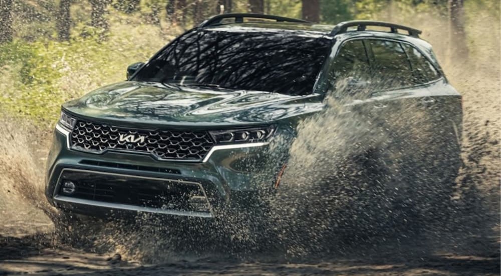 A gray 2023 Kia Sorento is shown driving off-road.