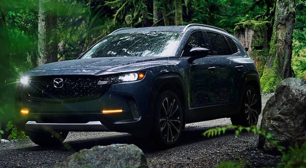 A blue 2023 Mazda CX-50 is shown driving off-road as it is ranked one of the Most Influential Autos of 2023.