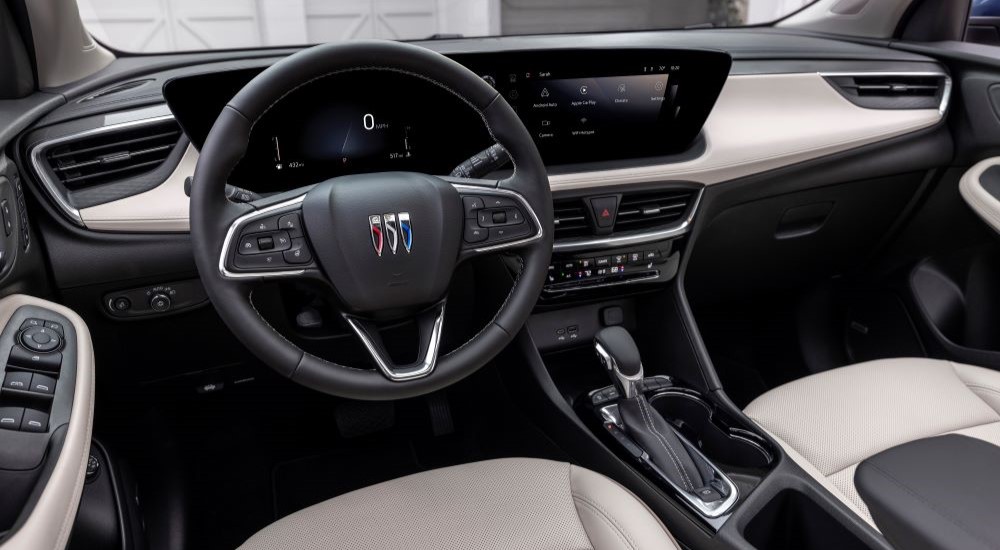 The black interior of a 2024 Buick Encore GX is shown from the driver's seat.