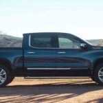 A black 2024 Chevy Silverado 1500 High Country is shown parked near a fence after competing in a 2024 Chevy Silverado 1500 vs 2024 Ford F-150 comparison.