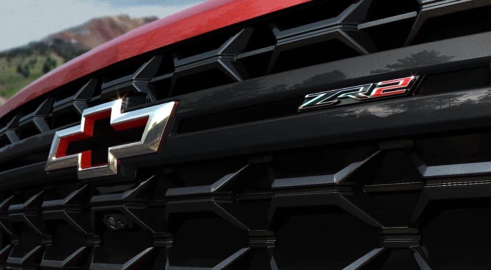 A close-up on the grille of a red 2024 Chevy Silverado 3500 HD ZR2 is shown.