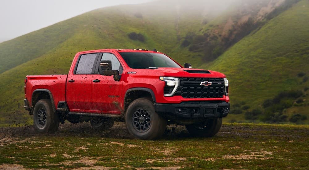 A red 2024 Chevy Silverado 3500 HD ZR2 is shown parked off-road.