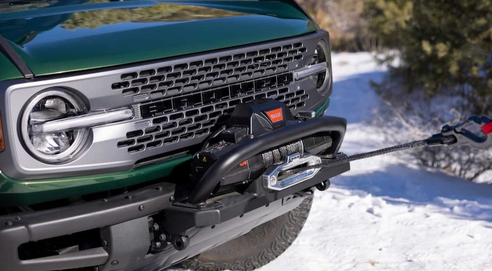 A WARN Winch Kit is shown being used on a green 2024 Ford Bronco Everglades.