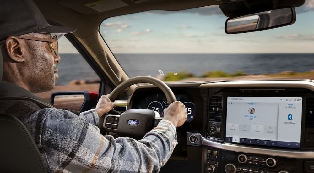 The black and tan interior and dash of a 2024 Ford F-150 is shown.