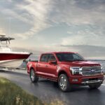 A red 2024 Ford F-150 is shown towing a boat.