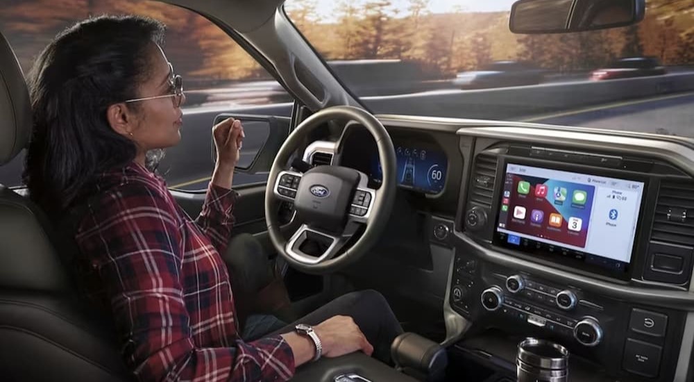 The black and gray interior and dash of a 2024 Ford F-150 is shown.