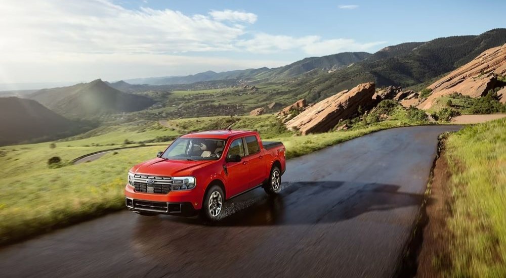 A red 2024 Ford Maverick is shown driving through the mountains.